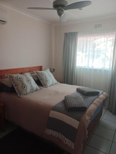 a bedroom with a bed with a ceiling fan and a window at The Roaches in White River
