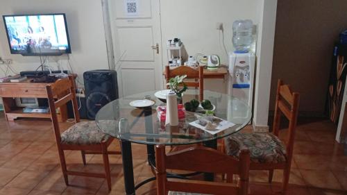 a glass table with chairs and a television in a room at Villa Kota Bunga Q4-17 in Cikundul