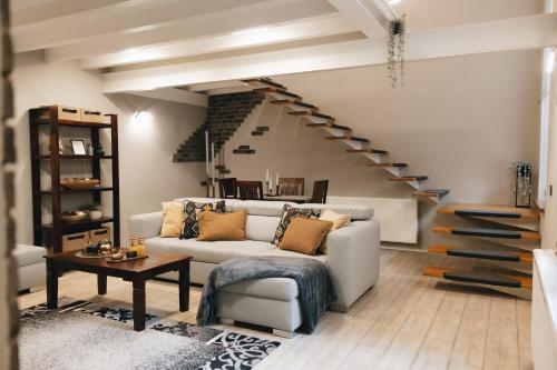 a living room with a white couch and stairs at VOK Luxury Home I City Loft I Central Arad in Arad