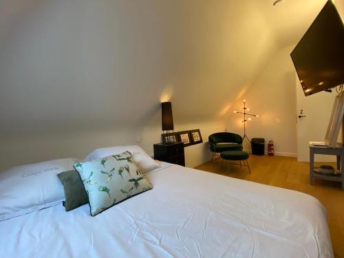 a bedroom with a white bed with a pillow on it at Oase d'Itegem - Wellness & Luxe in Heist-op-den-Berg