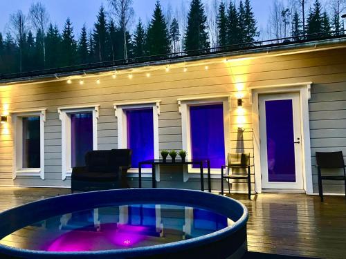 a patio with a hot tub in front of a house at Villa Renkaranta - Modern villa for 8-12 person, own beach, sauna & hot tub - surrounded by forests in Hämeenlinna