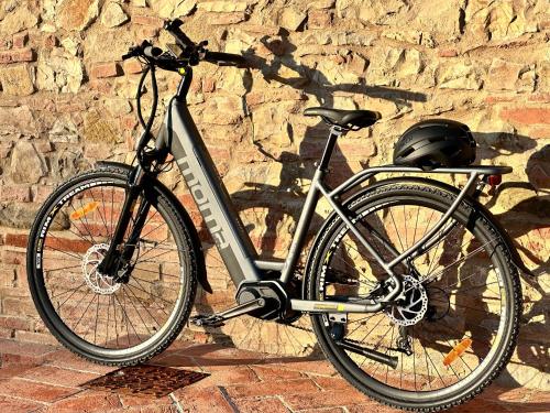 a bike parked next to a stone wall at Agriturismo La Frattina in Buonconvento