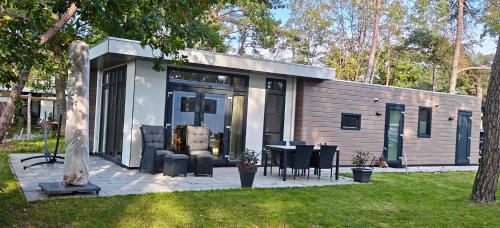 a small house with a table and chairs in a yard at Casa Bosrust - Luxe, rust, natuur en privacy in Haarle