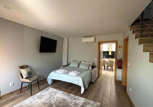 ein Schlafzimmer mit einem Bett und einem Stuhl in der Unterkunft Casa da Moura - Arcos de Valdevez in Arcos de Valdevez