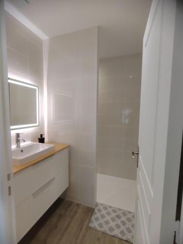 a white bathroom with a sink and a mirror at L'Atelier ,Calme, parking, centre Gémozac in Gémozac