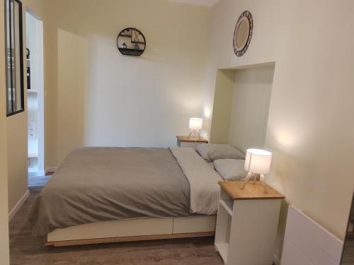ein Schlafzimmer mit einem Bett und zwei Lampen auf einem Tisch in der Unterkunft L'Atelier T2 entièrement rénover in Gémozac