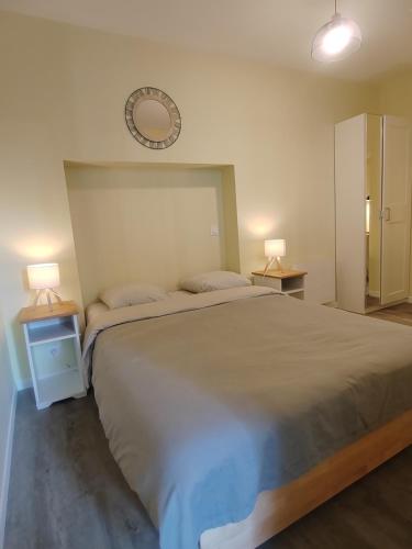 a bedroom with a large bed and two night stands at L'Atelier ,Calme, parking, centre Gémozac in Gémozac