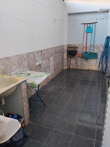 a room with a tiled floor with a sink and a table at Casa temporada RA capitolio in Capitólio