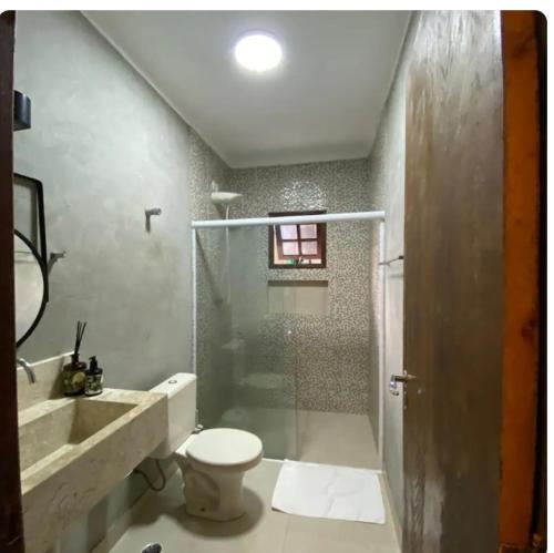 a bathroom with a shower and a toilet and a sink at Casa de Praia in Bertioga