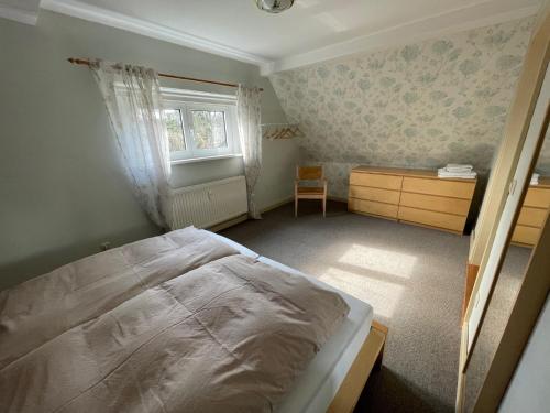 a bedroom with a bed and a desk and a window at Ferienwohnung Lahann in Saalfeld