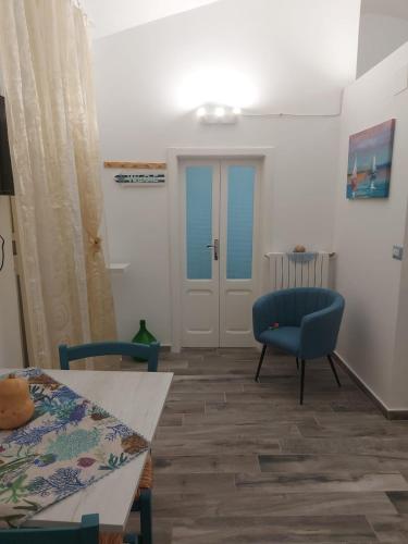 een woonkamer met een blauwe stoel en een tafel bij ACQUAMARINA - Home & Relax in Ascoli Satriano