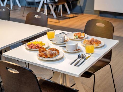 a table with plates of breakfast food on it at B&B HOTEL Milano Ornato in Milan