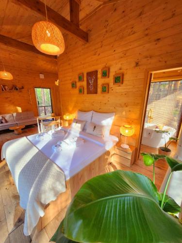 a bedroom with a large bed in a wooden room at Tree Houses Olszanka in Puszcza Mariańska