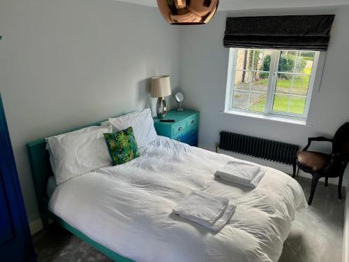 una camera da letto con un letto con asciugamani sopra di The Priory Cottage a Legbourne