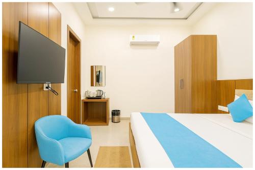 a bedroom with a bed and a blue chair at Mahavidya Road Hotel The Shrinath Premium Palace Near Masani Railway Station - Sri Krishna Janmabhoomi - Parking # Restaurant And Lift facilities - Fully Air conditioning Luxuary Room - Top Rated Hotel In Mathura in Mathura