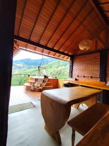 a dining room with a table and a large window at Pousada Café da Mata in Caparaó Velho