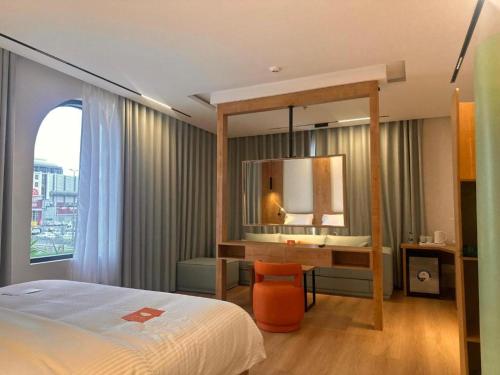 ein Schlafzimmer mit einem Bett und einem Schreibtisch mit Spiegel in der Unterkunft فندق منسي Monsi Hotel in Ta'if