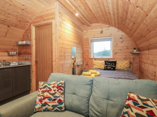 een woonkamer in een blokhut met een bank bij Oak in Ulverston