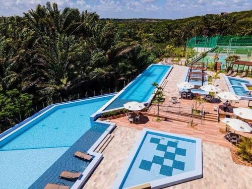 Apartamento térreo com jardim privativo في بارناميريم: اطلالة علوية على مسبح كبير مع مظلات