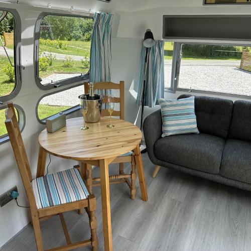 a living room with a table and a couch at Willow Valley Glamping in Bude