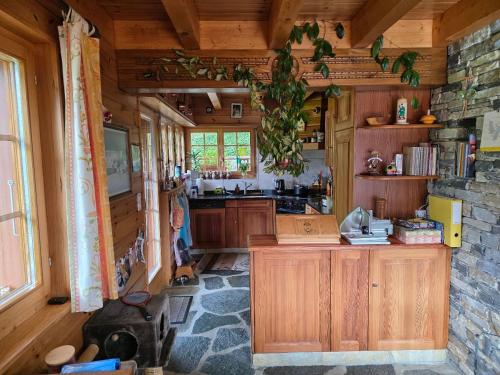 a kitchen with wooden cabinets and a stone wall at Chalet Famicha by Jolidi in Nendaz