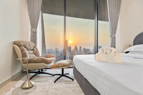 a bedroom with a bed and a chair and a window at Private Pool - Amazing 1BR Apartment in JVC in Dubai