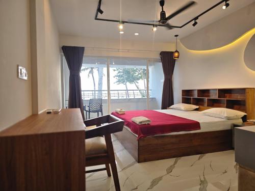 a bedroom with a large bed and a desk and a desk at Karthik Villa in Varkala