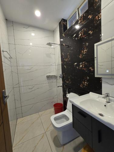 a bathroom with a toilet and a sink and a shower at Karthik Villa in Varkala