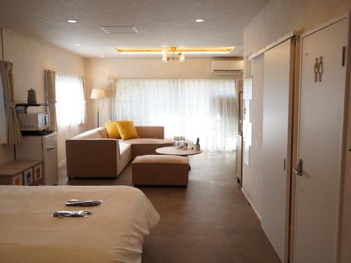 een kamer met een bed en een bank en een woonkamer bij スタイリッシュハウス博多 in Fukuoka