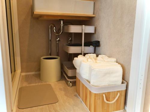 een badkamer met een wastafel en een stapel handdoeken bij スタイリッシュハウス博多 in Fukuoka