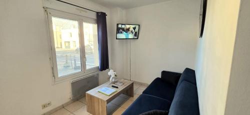a living room with a blue couch and a window at La Proue T2 étoilé in Saint-Méloir-des-Ondes