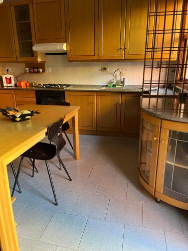 a kitchen with wooden cabinets and a wooden table at Fuori Arena in Casalecchio di Reno