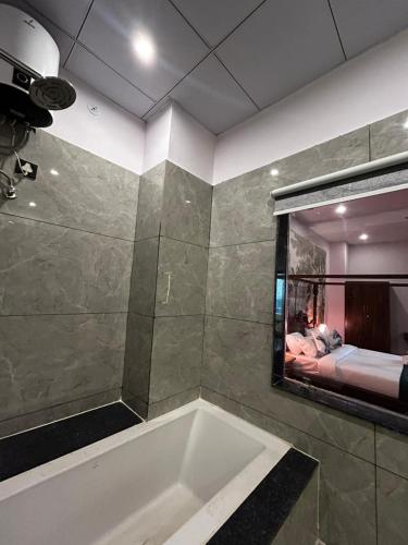 a bath tub in a bathroom with a mirror at Aijasvan Hotel in Sawāi Mādhopur