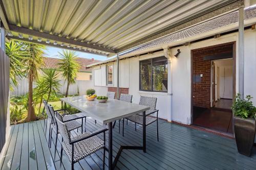 een terras met een tafel en stoelen op een dek bij Perth Boutique Heritage in Perth