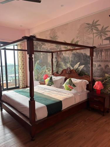 a bedroom with a canopy bed with a painting on the wall at Aijasvan Resort in Sawāi Mādhopur
