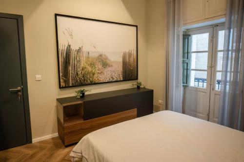 une chambre avec un lit et un tableau au mur dans l'établissement RUWTS Valletta Central Maisonette, à La Valette