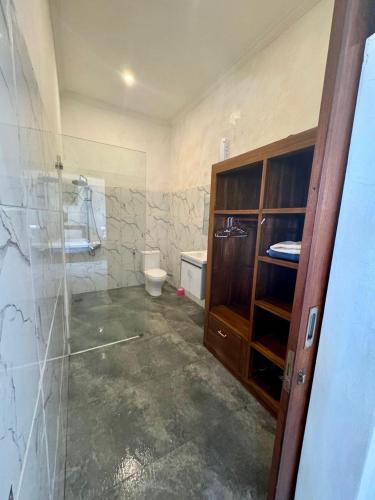 a bathroom with a toilet and a glass door at Elegant Jaden Villa Cemagi in Mengwi