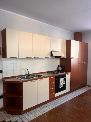 a kitchen with white cabinets and a sink and a stove at Da Zia Mery in Edolo
