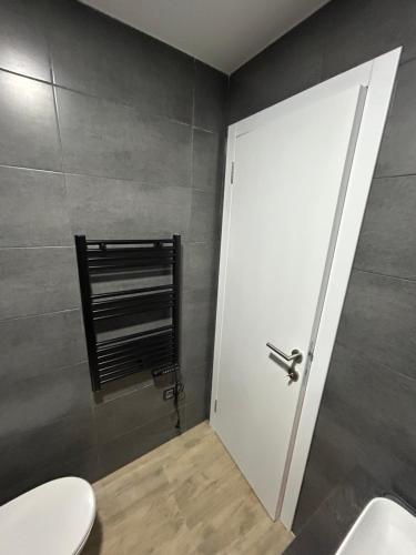 a bathroom with a white door and a toilet at B8 Residence hill in Kopaonik