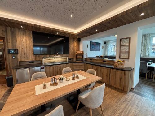 a large kitchen with a wooden table and chairs at Landgasthof Bierfriedl in Pruggern