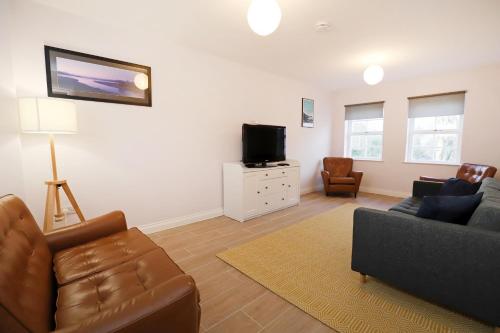 a living room with a couch and a tv at Royal Hillsborough Village Luxury Townhouse in Hillsborough