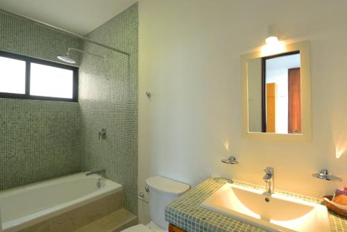 a bathroom with a sink and a tub and a toilet at Yuum Ha Boutique Hotel in Río Lagartos