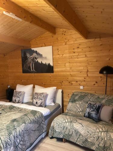 two beds in a room with wooden walls at Relax Hütten & Spa Gröden in Groeden
