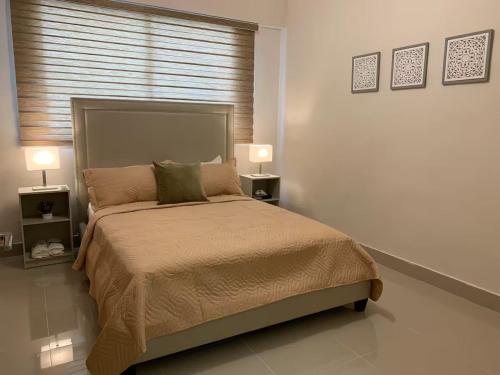 Departamento en Santo Domingo في سانتو دومينغو: غرفة نوم بسرير كبير مع مصباحين