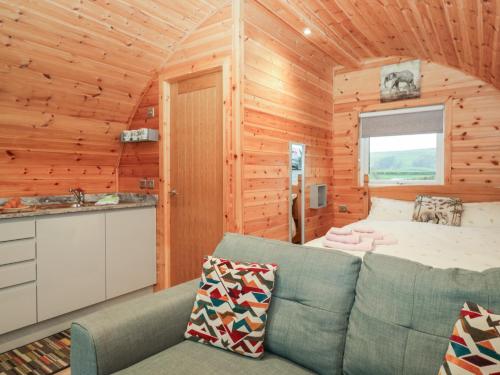 a living room with a couch and a bed in a cabin at Willow in Ulverston