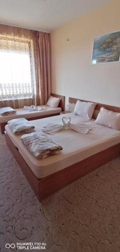 a bedroom with two beds and a window at Vila Panorama in Izgrev