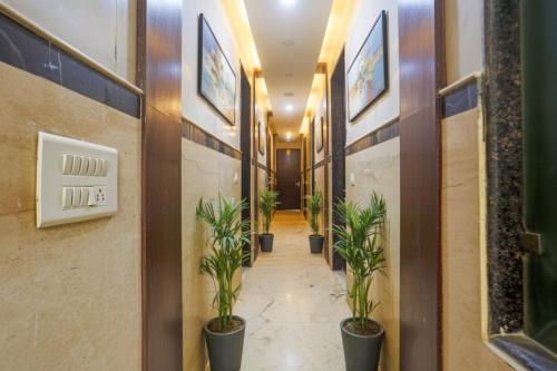 a corridor with potted plants in a hallway at Via Geras - Nehru Place Market in New Delhi