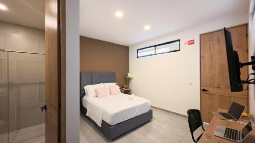 a bedroom with a bed and a desk with a laptop at Hotel El Cedro Exclusive in Florencia