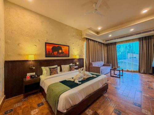 a bedroom with a bed and a chair in a room at Spree Resort Jim Corbett in Belparāo