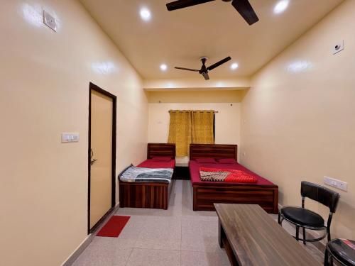 2 bedden in een kamer met een plafondventilator bij Studio 302 Premium Skyline with Terrace view in Deoghar